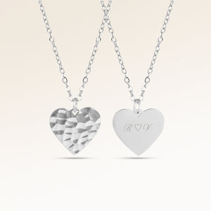 Personligt hjärtformat silverhalsband med vågig yta och plats för gravyr av text, koordinater eller handstil på baksidan