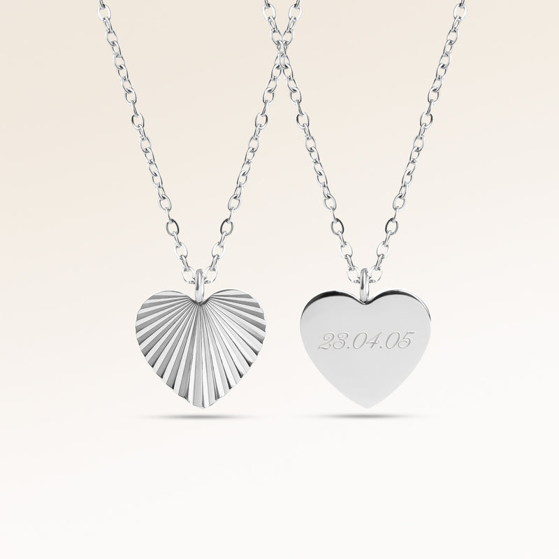 Personligt hjärtformat silverhalsband med räfflat solstrålemönster och plats för gravyr av text, koordinater eller handstil på baksidan