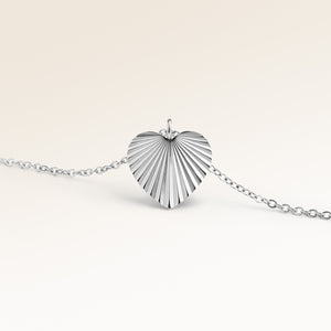 Personligt hjärtformat silverhalsband med räfflat solstrålemönster och plats för gravyr av text, koordinater eller handstil på baksidan